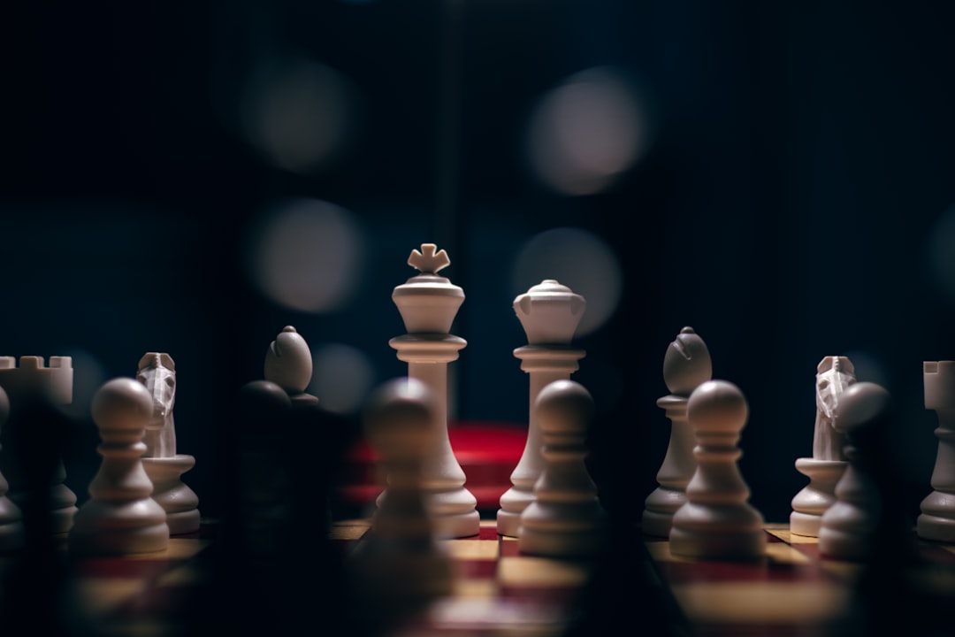 A minimal, brightly lit photo of a single chess pawn in a checkmate position against a king, representing a smart strategy allowing a smaller player to win.
